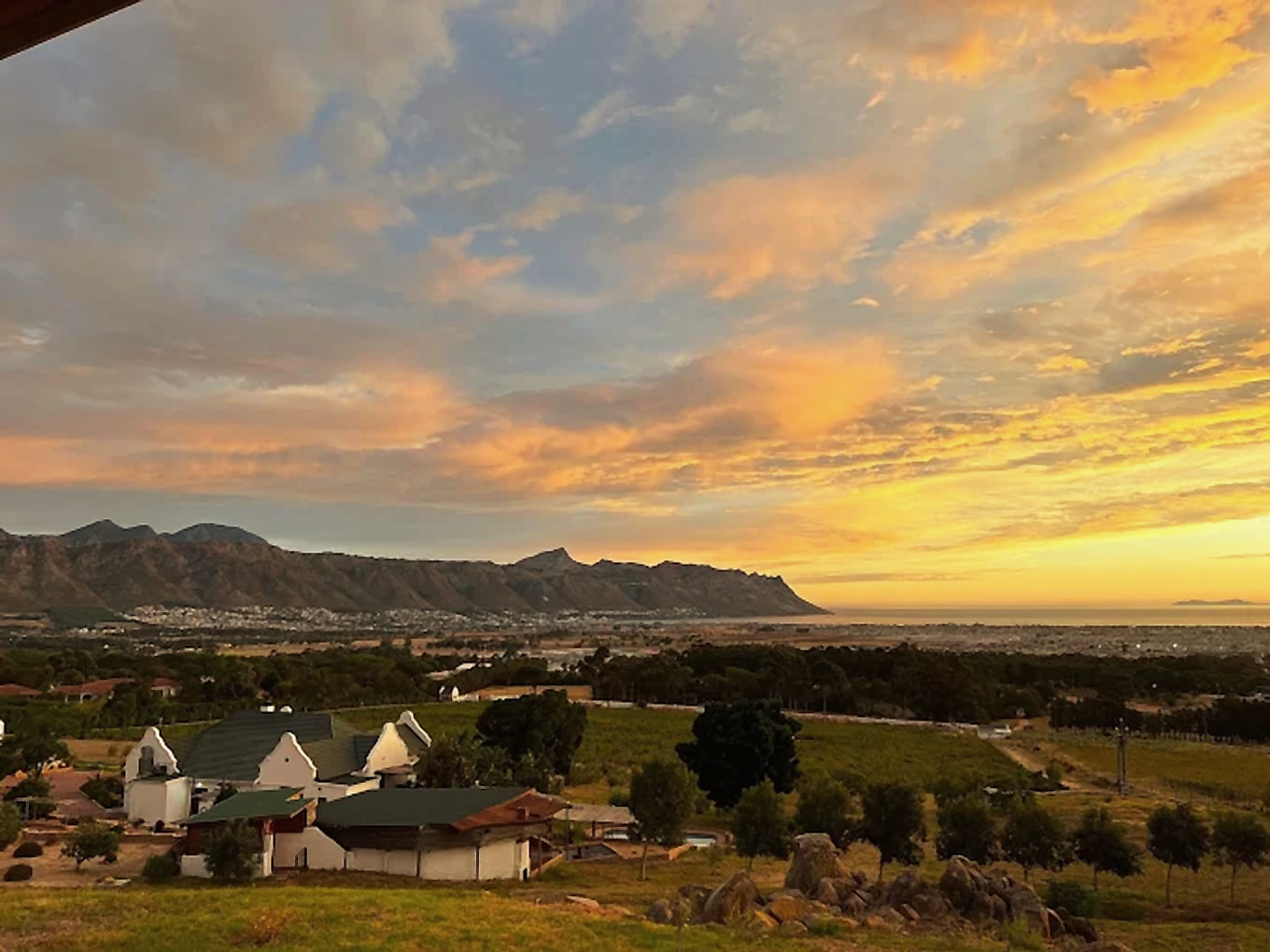 Sunset over the estate buildings, with the mountains and False Bay beyond