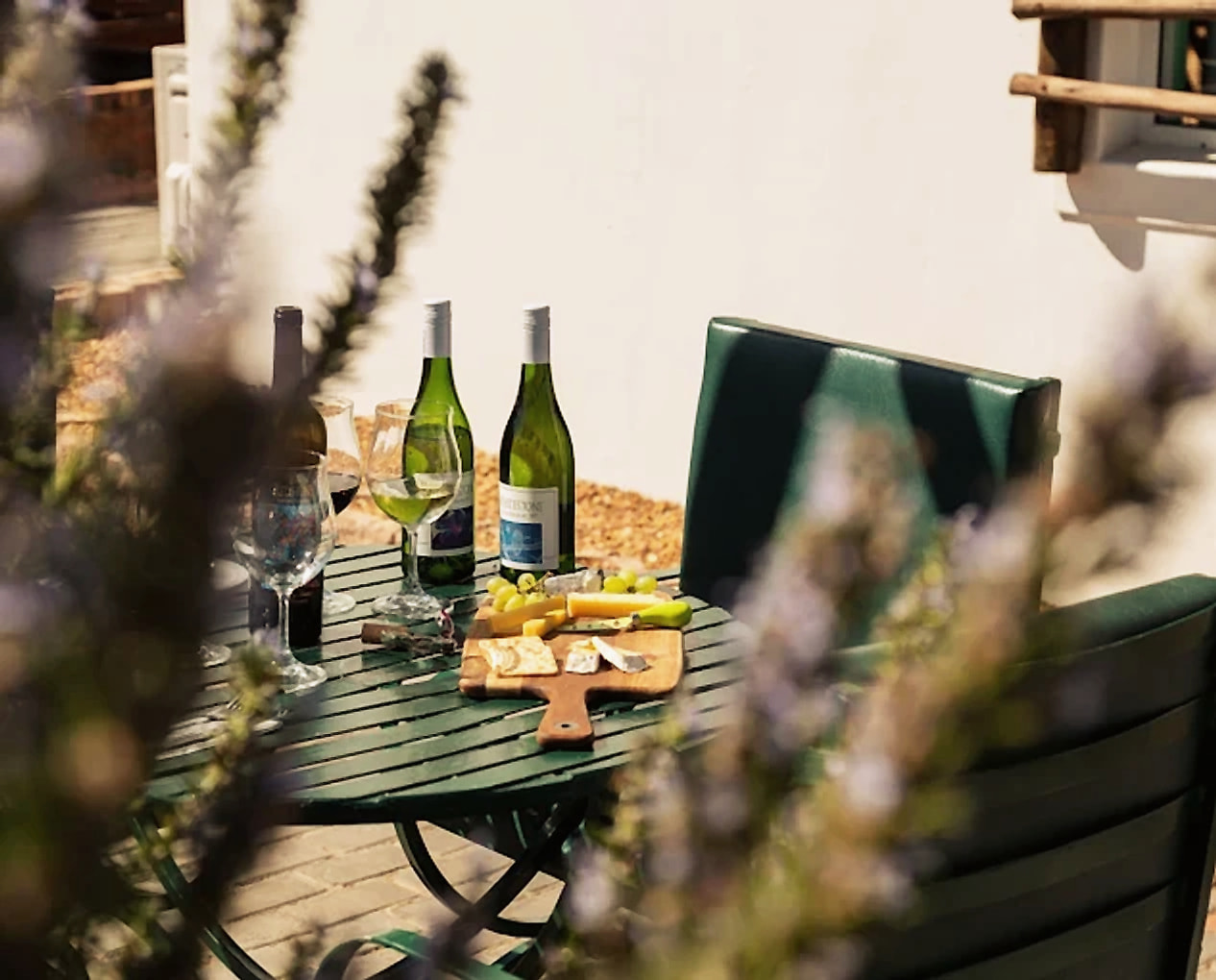 Estate wines and a cheese board on a sunny terrace table